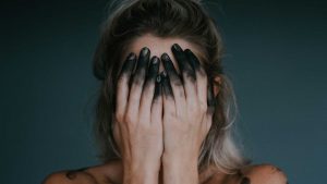 deprimert kvinne med sorte fingre
